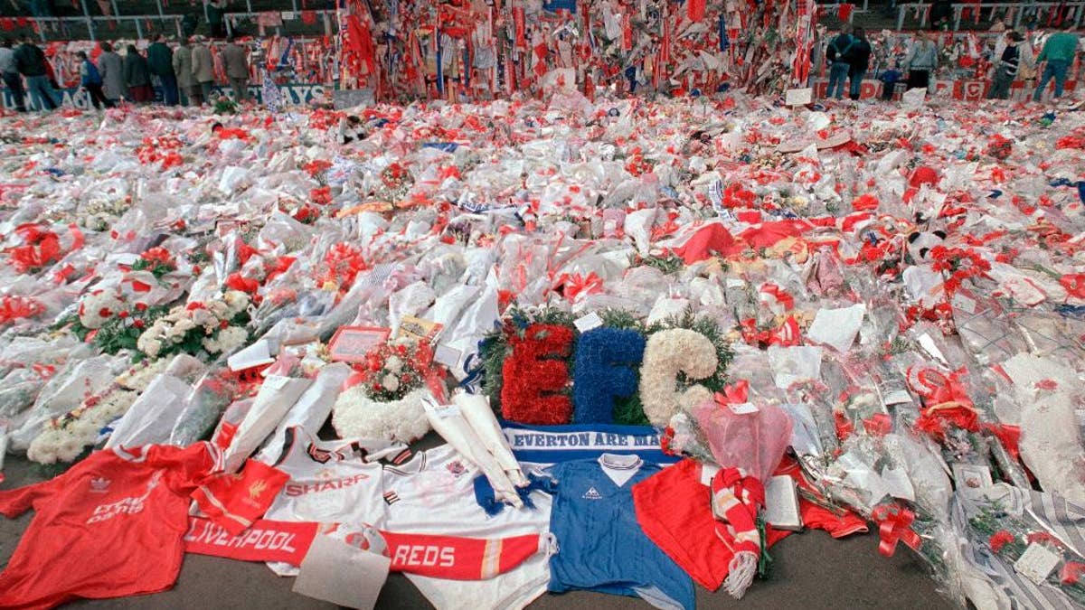 FILE- In this file photo dated April 17, 1989, floral tributes are placed by soccer fans at the 'Kop' end of Anfield Stadium in Liverpool, England, on April 17, 1989, after the Hillsborough April 15 tragedy when fans surged forward during the Cup semi-final between Liverpool and Nottingham Forest at Hillsborough Stadium killing 96 people. The 96 Liverpool soccer fans who died in the Hillsborough Stadium disaster were “unlawfully killed” because of errors by the police, a jury concluded Tuesday April 26, 2016. (AP Photo/ Peter Kemp, File)