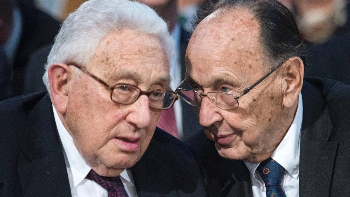 FILE - In this Oct. 9, 2014 file photo Former U.S. Secretary of State Henry Kissinger, left, talks to Hans-Dietrich Genscher, former foreign minister of West Germany, right, prior to a memorial service in the St Nikolai Church marking the 25th anniversary of the peaceful German revolution in Leipzig, Germany. Genscher died Friday, April 1, 2016 at the age of 89. (AP Photo/Jens Meyer, file)