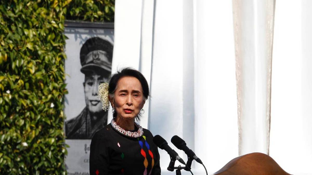 Myanmar State Counsellor Aung San Suu Kyi, standing by a portrait of her late father and national hero Gen. Aung San and the Panglong monument, delivers a speech during a ceremony to mark the 70th anniversary of Union Day Sunday, Feb.12, 2017, in Panglong, Southern Shan State, over 800 kilometers (500 miles) northeast of Yangon, Myanmar. (AP Photo/Thein Zaw)