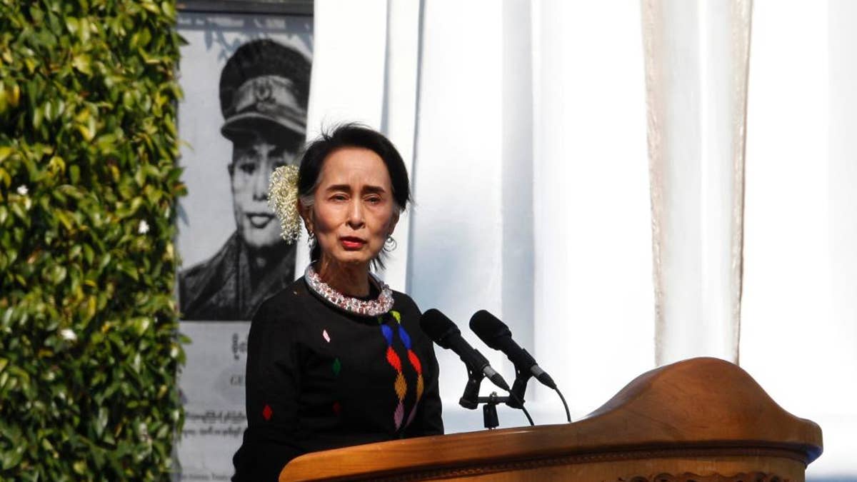 Myanmar State Counsellor Aung San Suu Kyi, standing by a portrait of her late father and national hero Gen. Aung San and the Panglong monument, delivers a speech during a ceremony to mark the 70th anniversary of Union Day Sunday, Feb.12, 2017, in Panglong, Southern Shan State, over 800 kilometers (500 miles) northeast of Yangon, Myanmar. (AP Photo/Thein Zaw)