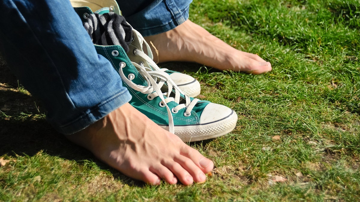 feet and shoes in the grass sweaty feet istock medium