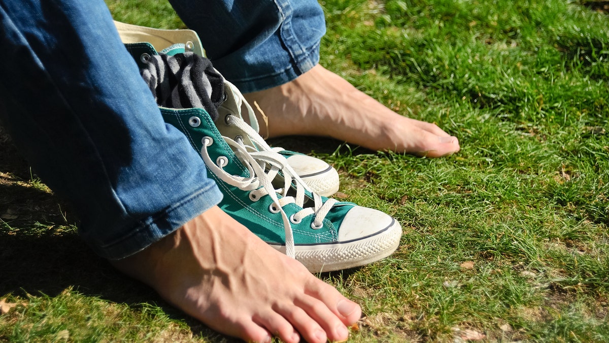 feet and shoes in the grass sweaty feet istock medium