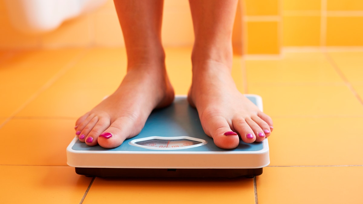 feet on a scale weighing yourself losing weight istock