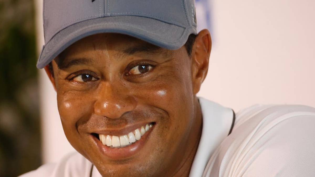 FILE - In this July 28, 2015, file photo, Tiger Woods smiles as he answers a question during a news conference prior to the start of the Quicken Loans National golf tournament, in Gainesville, Va. Tiger Woods says he hopes to play next month in the PGA's Safeway Open in Napa, California, his first competitive golf since August 2015. (AP Photo/Steve Helber, File)
