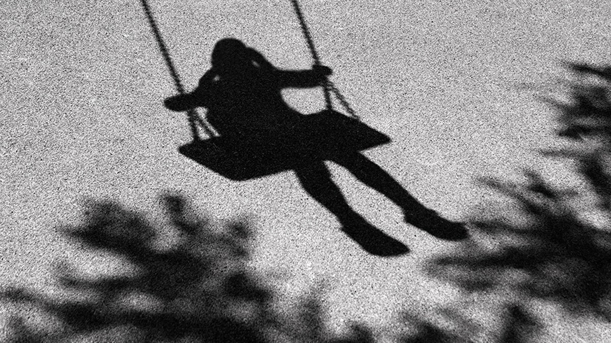 Blurry shadows of girl on a swing and a tree branch