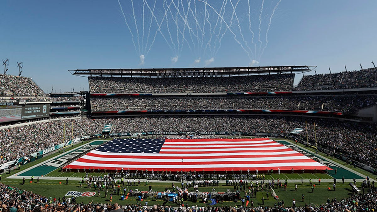 An American flag covers the field before an NFL football game between the Philadelphia Eagles and the New York Giants, Sunday, Sept. 24, 2017, in Philadelphia. (AP Photo/Michael Perez)