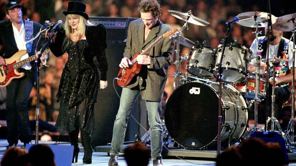 FILE - In a Monday, Jan. 18, 1993 file photo, the rock group Fleetwood Mac, reuniting after 13 years apart, performs during the American Gala evening at the Capital Centre in Landover, Md.   From left to right are, John McVie, Stevie Nicks, Lindsey Buckingham and Mick Fleetwood. Fleetwood Mac annunced Sunday, Oct. 27, 2013 that the group is canceling planned performances in Australia and New Zealand as bassist John McVie is treated for cancer. (AP Photo/Amy Sancetta, File)