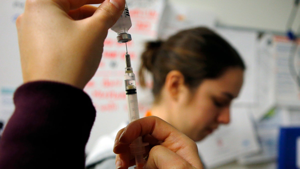 Nurses prepare influenza vaccine injections during a flu shot clinic at Dorchester House, a health care clinic, in Boston, Massachusetts January 12, 2013. Influenza has officially reached epidemic proportions in the United States, with 7.3 percent of deaths last week caused by pneumonia and the flu, the U.S. Centers for Disease Control and Prevention said on January 11. REUTERS/Brian Snyder (UNITED STATES - Tags: HEALTH SOCIETY) - RTR3CCV9