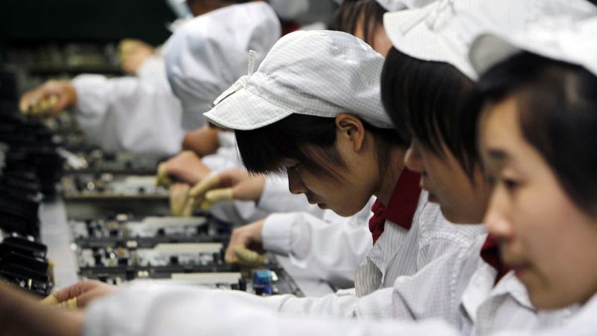 FILE-In this Wednesday, May 26, 2010, file photo, staff members work on the production line at the Foxconn complex in Shenzhen, China. Foxconn, the company that makes Apples iPhones suspended production at a factory in China on Monday, Sept. 24, 2012, after a brawl by as many as 2,000 employees at a dormitory injured 40 people.  The fight, the cause of which was under investigation, erupted Sunday night at a privately managed dormitory near a Foxconn Technology Group factory in the northern city of Taiyuan, the company and Chinese police said.(AP Photo/Kin Cheung, File)