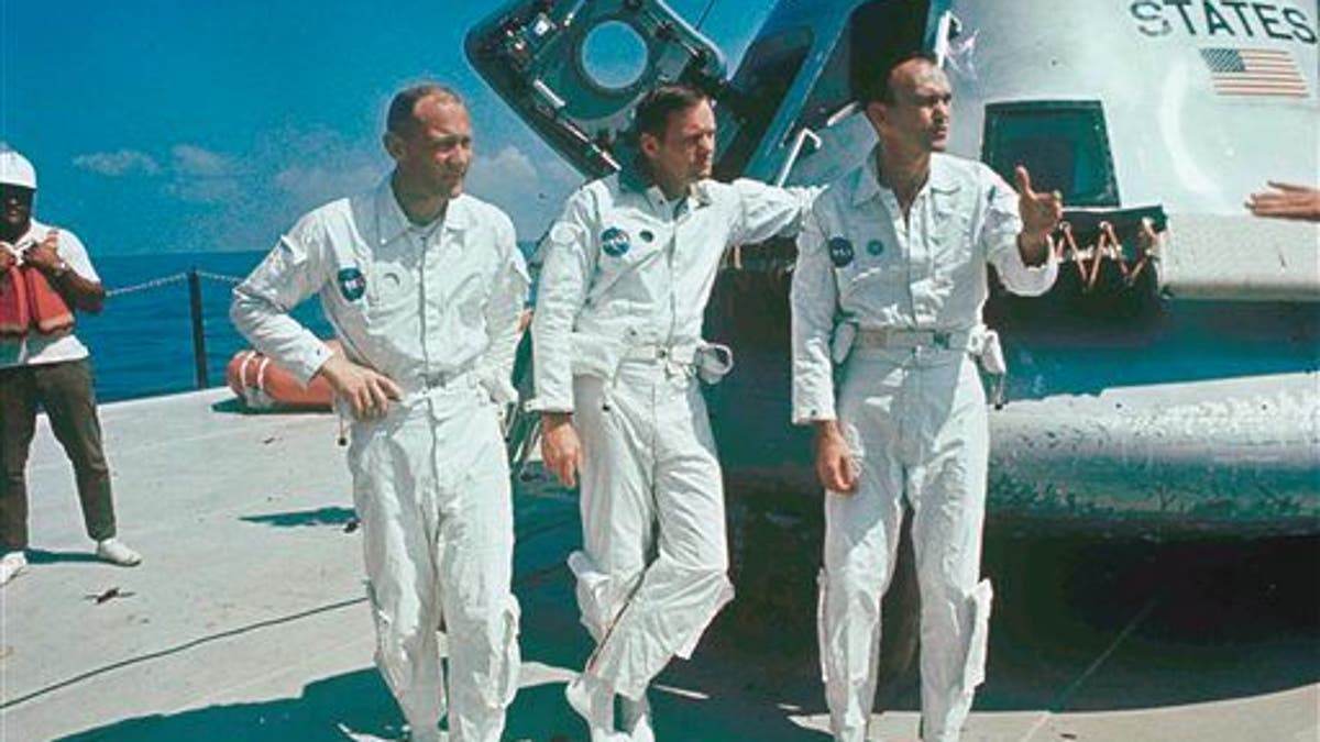 **ADVANCE FOR THURSDAY, JULY 16**  FILE - In this 1969 file photo,  Apollo 11 astronauts stand next to their spacecraft in 1969, from left to right:  Col. Edwin E. Aldrin, lunar module pilot; Neil Armstrong, flight commander; and Lt. Michael Collins, command module pilot.  (AP Photo, file)