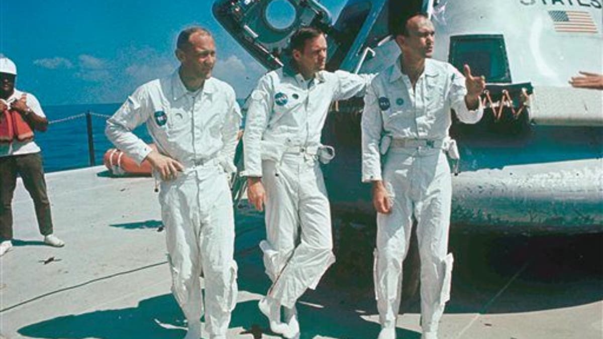 **ADVANCE FOR THURSDAY, JULY 16**  FILE - In this 1969 file photo,  Apollo 11 astronauts stand next to their spacecraft in 1969, from left to right:  Col. Edwin E. Aldrin, lunar module pilot; Neil Armstrong, flight commander; and Lt. Michael Collins, command module pilot.  (AP Photo, file)