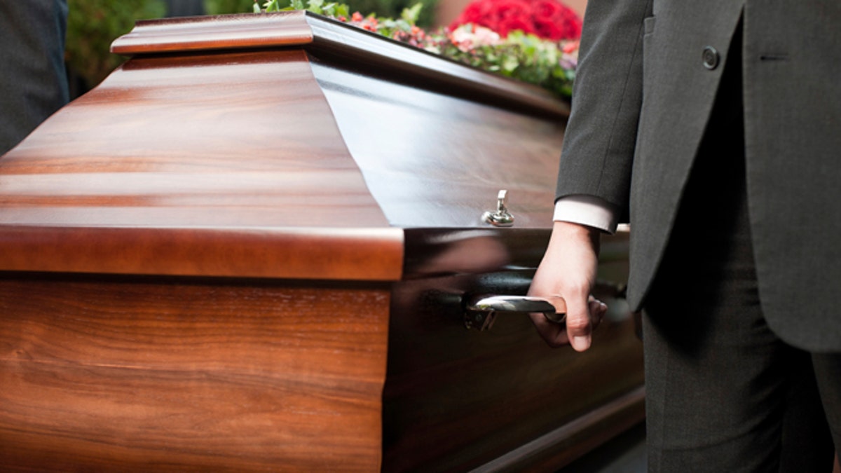 coffin bearer carrying casket at funeral