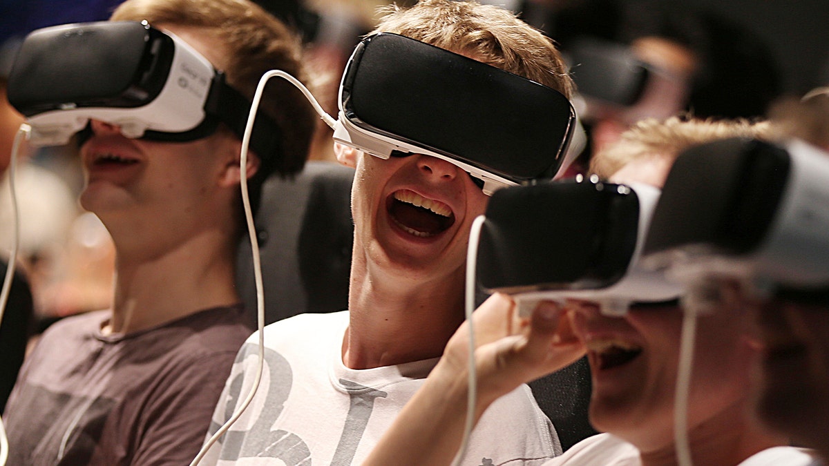 Persons with virtual reality headsets have fun at the gamescom fair in Cologne, Germany, Wednesday Aug. 23, 2017. The leading European trade fair for digital gaming culture is the meeting point for global companies from the entertainment industry and the international gaming community. (Oliver Berg/dpa via AP)