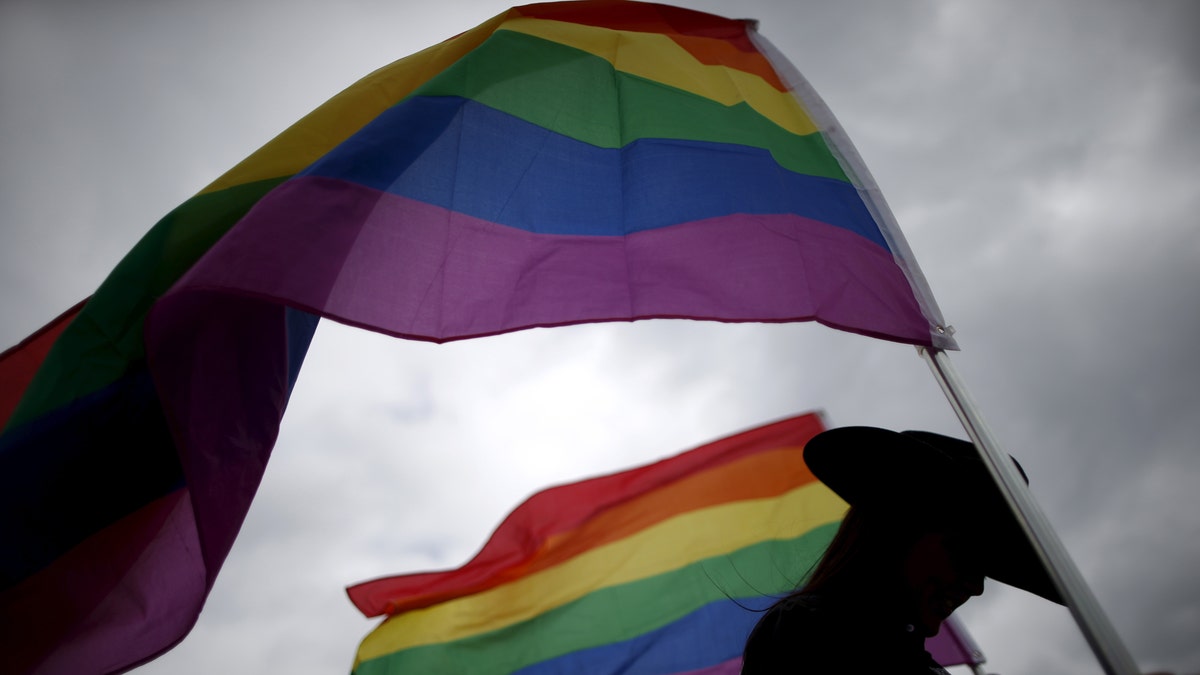 A woman holds rainbow flags for the grand entry at the International Gay Rodeo Association's Rodeo In the Rock in Little Rock, Arkansas, United States April 26, 2015. Contestants at the International Gay Rodeo in Arkansas, a Bible Belt state with a same-sex marriage ban on its books, competed in events from barrel racing to bull riding on the soft soil of a fairground that looked like just any small-scale rodeo held throughout the United States. The U.S. Supreme Court is expected to rule in June whether to strike down bans on gay marriage nationwide. Arkansas has been one of the front-line states in the battle between cultural conservatives and those seeking expanded rights for the lesbian, gay, bisexual and transgender (LGBT) community. REUTERS/Lucy Nicholson TPX IMAGES OF THE DAYPICTURE 1 OF 27 FOR WIDER IMAGE STORY "GAY RODEO IN LITTLE ROCK" SEARCH "RODEO LUCY" FOR ALL IMAGES TPX IMAGES OF THE DAY TPX IMAGES OF THE DAY - RTX1DSCH