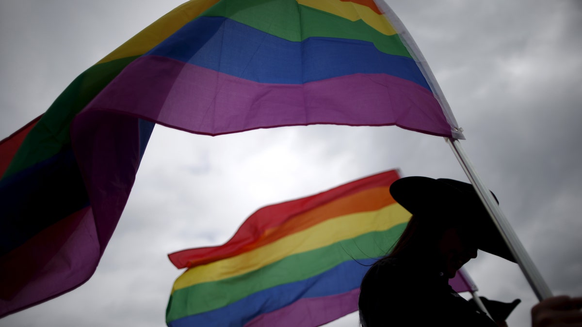 A woman holds rainbow flags for the grand entry at the International Gay Rodeo Association's Rodeo In the Rock in Little Rock, Arkansas, United States April 26, 2015. Contestants at the International Gay Rodeo in Arkansas, a Bible Belt state with a same-sex marriage ban on its books, competed in events from barrel racing to bull riding on the soft soil of a fairground that looked like just any small-scale rodeo held throughout the United States. The U.S. Supreme Court is expected to rule in June whether to strike down bans on gay marriage nationwide. Arkansas has been one of the front-line states in the battle between cultural conservatives and those seeking expanded rights for the lesbian, gay, bisexual and transgender (LGBT) community. REUTERS/Lucy Nicholson TPX IMAGES OF THE DAYPICTURE 1 OF 27 FOR WIDER IMAGE STORY "GAY RODEO IN LITTLE ROCK" SEARCH "RODEO LUCY" FOR ALL IMAGES TPX IMAGES OF THE DAY TPX IMAGES OF THE DAY - RTX1DSCH