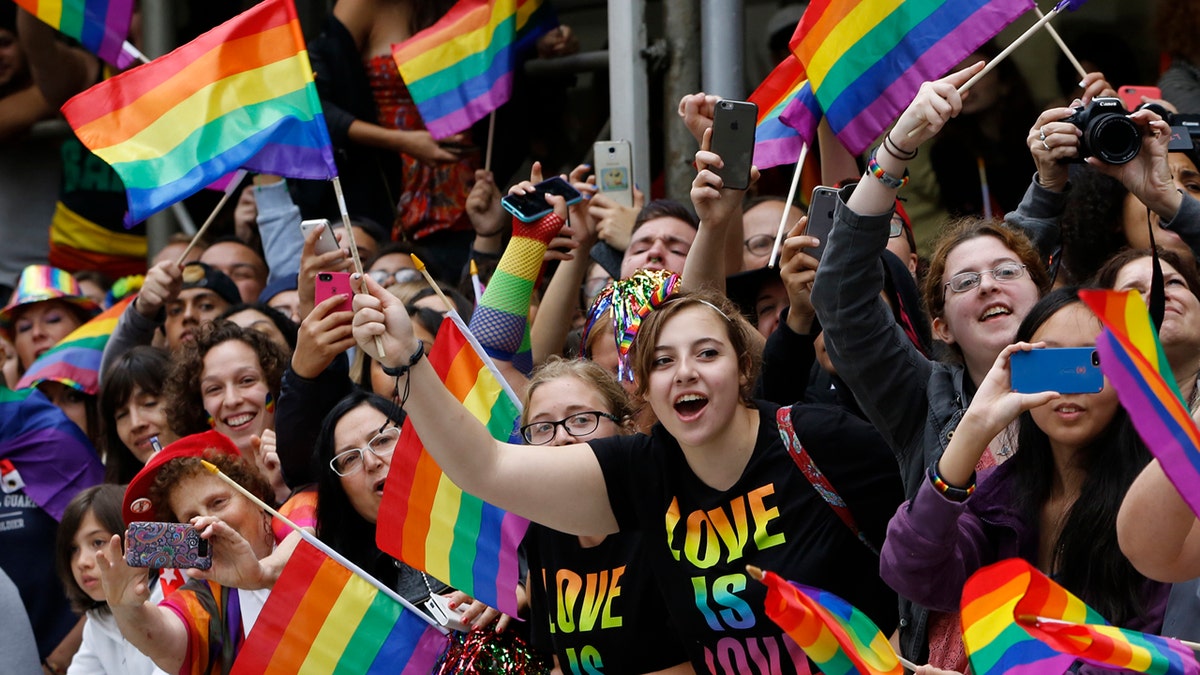 FILE - In this June 28, 2015 file photo, crowd waves rainbow flags during the Heritage Pride March in New York. Tennis legend Billie Jean King will be one of the grand marshals of New York City's gay pride march as cities around the world hold LGBT pride events. New York's march will pass by the Stonewall National Monument in Greenwich Village on Sunday, June 24, 2018, before heading up Fifth Avenue. (AP Photo/Kathy Willens, File)