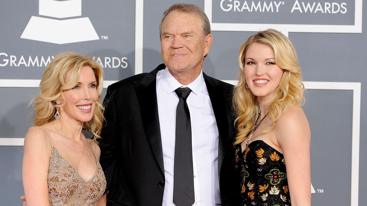 FILE - In this Feb. 12, 2012 file photo, Glen Campbell, center, Kim Woolen, left, and Ashley Campbell arrive at the 54th annual Grammy Awards in Los Angeles. Campbell, the grinning, high-pitched entertainer who had such hits as 