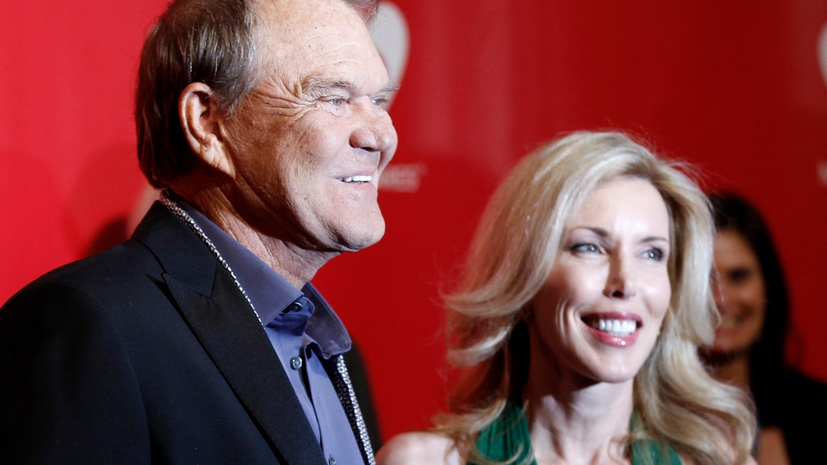 Musician Glen Campbell (L) and wife Kim Woollen pose at the 2012 MusiCares Person of the Year tribute honoring Paul McCartney in Los Angeles, February 10, 2012. REUTERS/Danny Moloshok (UNITED STATES - Tags: ENTERTAINMENT) - RTR2XN1D