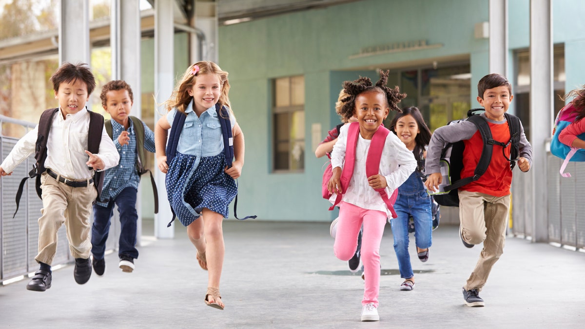 Group of elementary school kids running in a school corridor