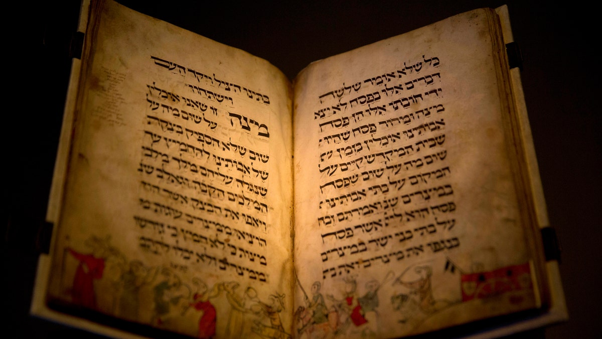 In this photo taken Wednesday, April 20, 2016, the famed Birds' Head Haggadah, a medieval copy of a text read around the Passover holiday table, is seen on display at the Israel Museum in Jerusalem. The grandchildren of one of the earliest Jewish victims of the Nazis are laying claim to a jewel of Israel's top museum: the world's oldest surviving illustrated Passover manuscript. (AP Photo/Sebastian Scheiner)