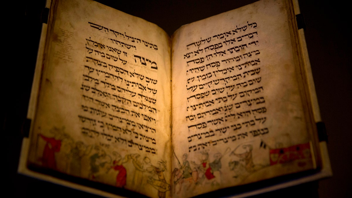 In this photo taken Wednesday, April 20, 2016, the famed Birds' Head Haggadah, a medieval copy of a text read around the Passover holiday table, is seen on display at the Israel Museum in Jerusalem. The grandchildren of one of the earliest Jewish victims of the Nazis are laying claim to a jewel of Israel's top museum: the world's oldest surviving illustrated Passover manuscript. (AP Photo/Sebastian Scheiner)