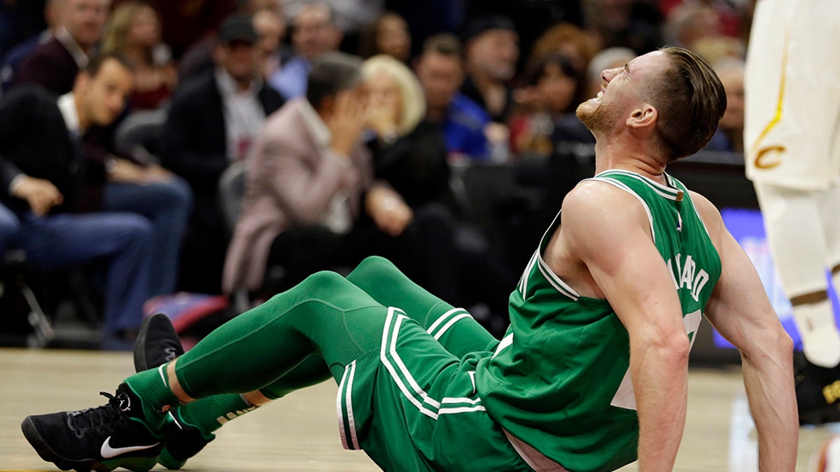 Gordon Hayward, de los Celtics de Boston, hace una mueca de dolor tras sufrir una fractura del tobillo izquierdo durante el partido inaugural de la temporada ante los Cavaliers de Cleveland, el martes 17 de octubre de 2017 (AP Foto/Tony Dejak)