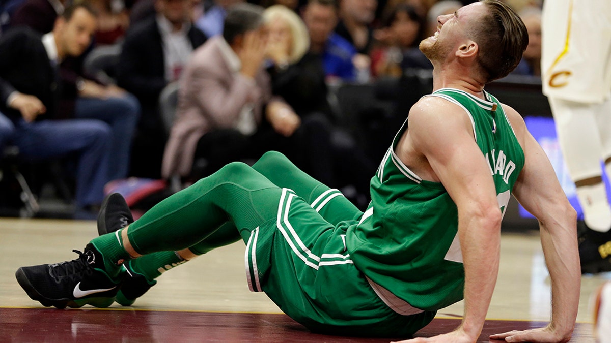 Gordon Hayward, de los Celtics de Boston, hace una mueca de dolor tras sufrir una fractura del tobillo izquierdo durante el partido inaugural de la temporada ante los Cavaliers de Cleveland, el martes 17 de octubre de 2017 (AP Foto/Tony Dejak)