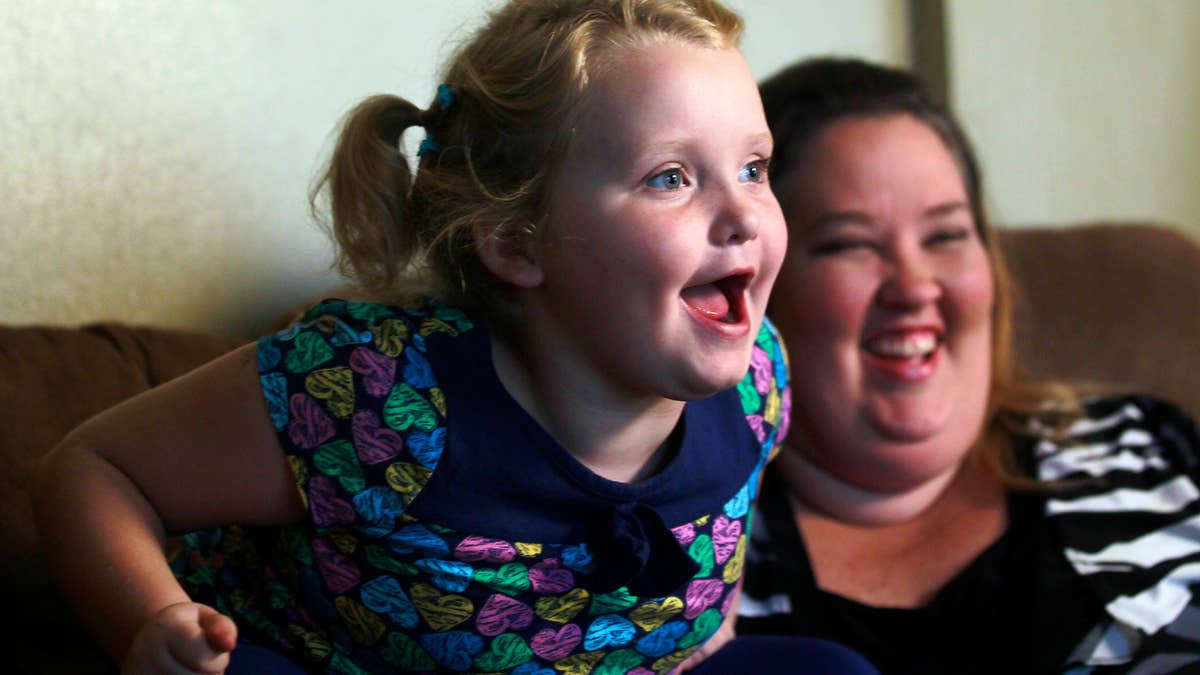 Alana "Honey Boo Boo" Thompson speaks during an interview as her mother, June Shannon, looks on in her home in McIntyre, Georgia