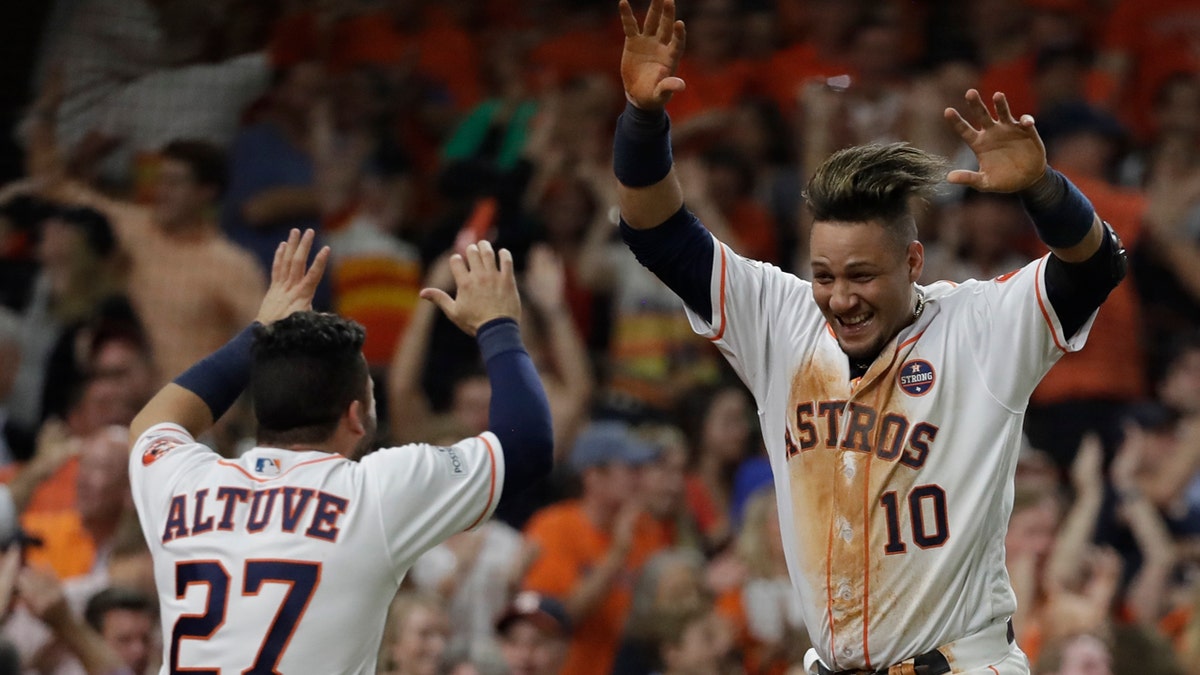 Houston Astros' Yuli Gurriel is congratulated by Jose Altuve after scoring during the fifth inning of Game 7 of baseball's American League Championship Series against the New York Yankees Saturday, Oct. 21, 2017, in Houston. (AP Photo/David J. Phillip)