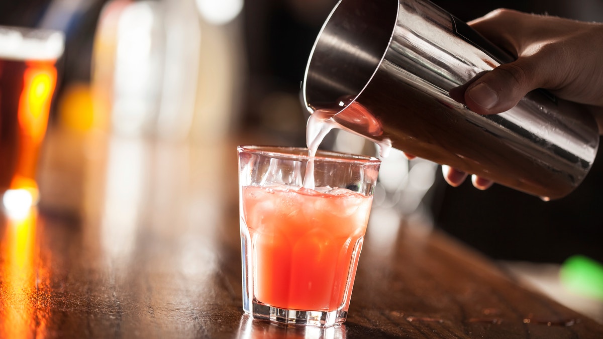 Barman serving a cocktail from a shaker