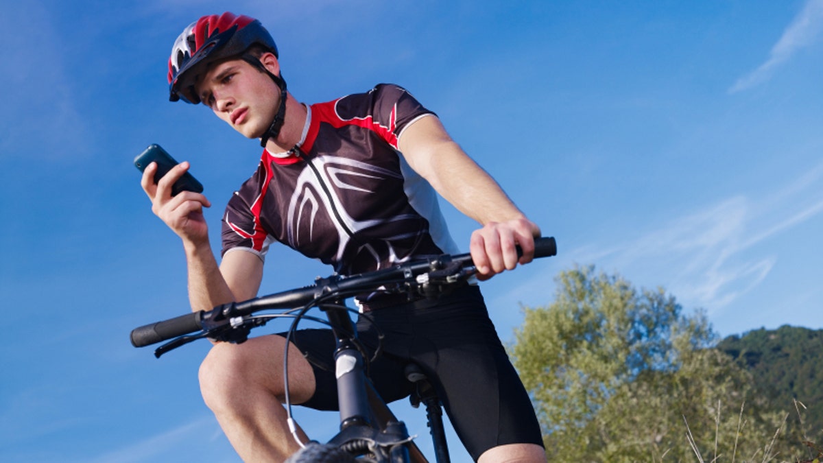 young man with telephone riding mountain bike
