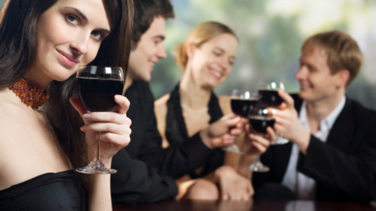 Two young couples with red-wine glasses at celebration or party