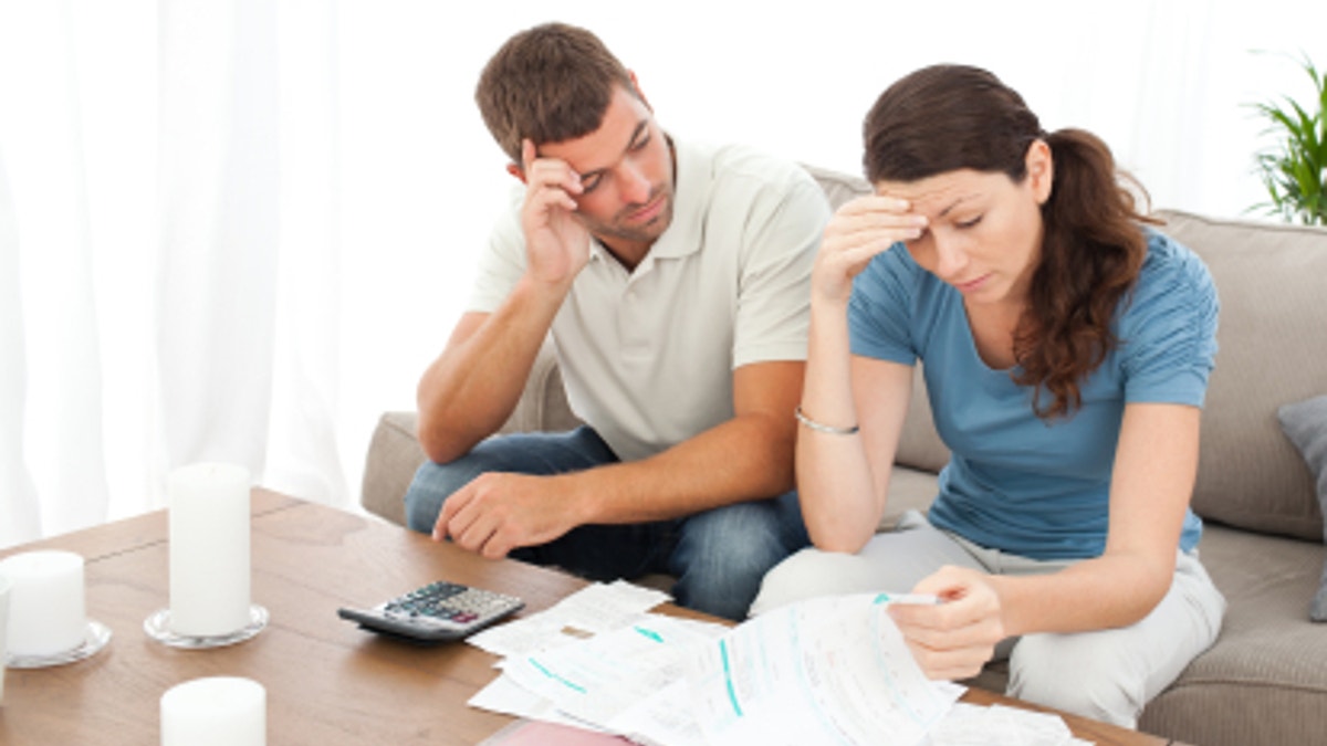 Worried couple doing their accounts in the living room