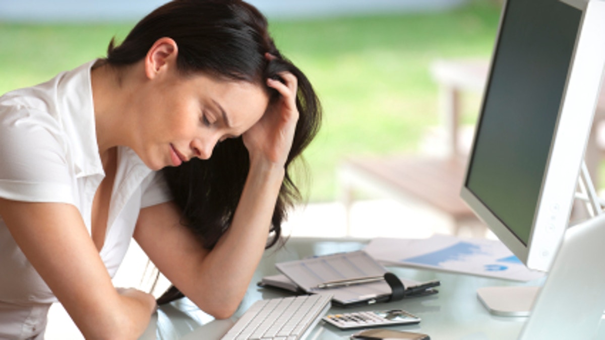Woman looking stressed at her desk