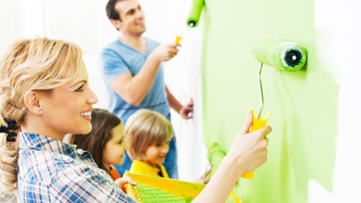 Happy family painting walls.