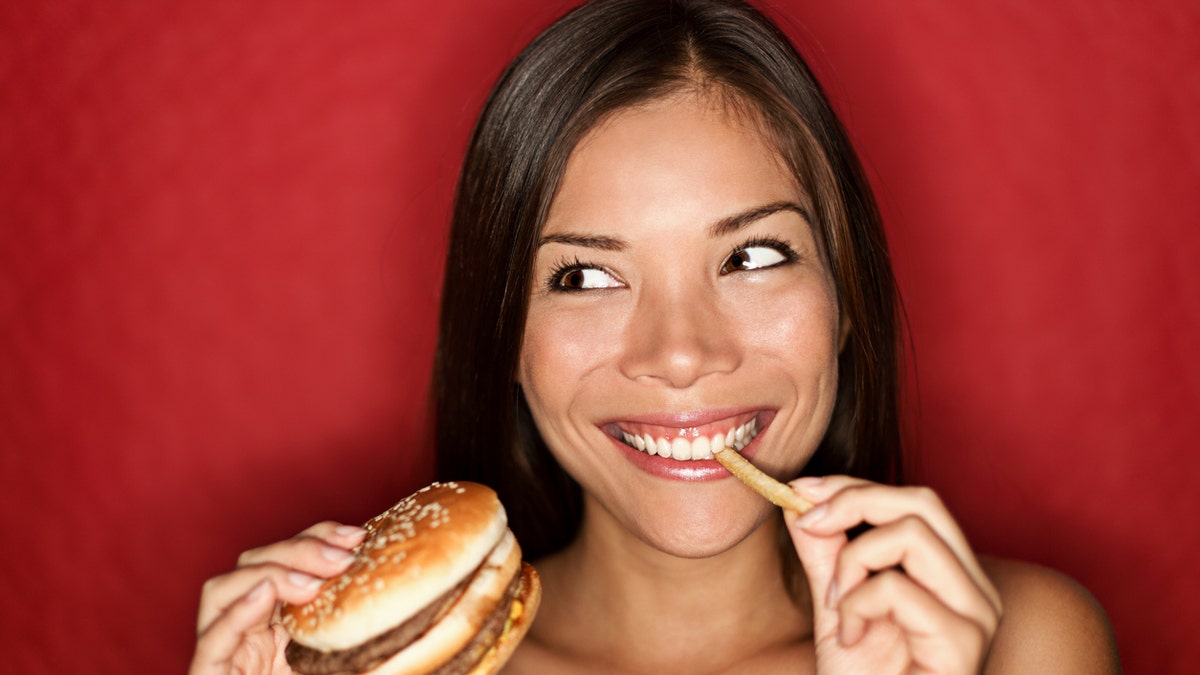 Woman eating burger iStock