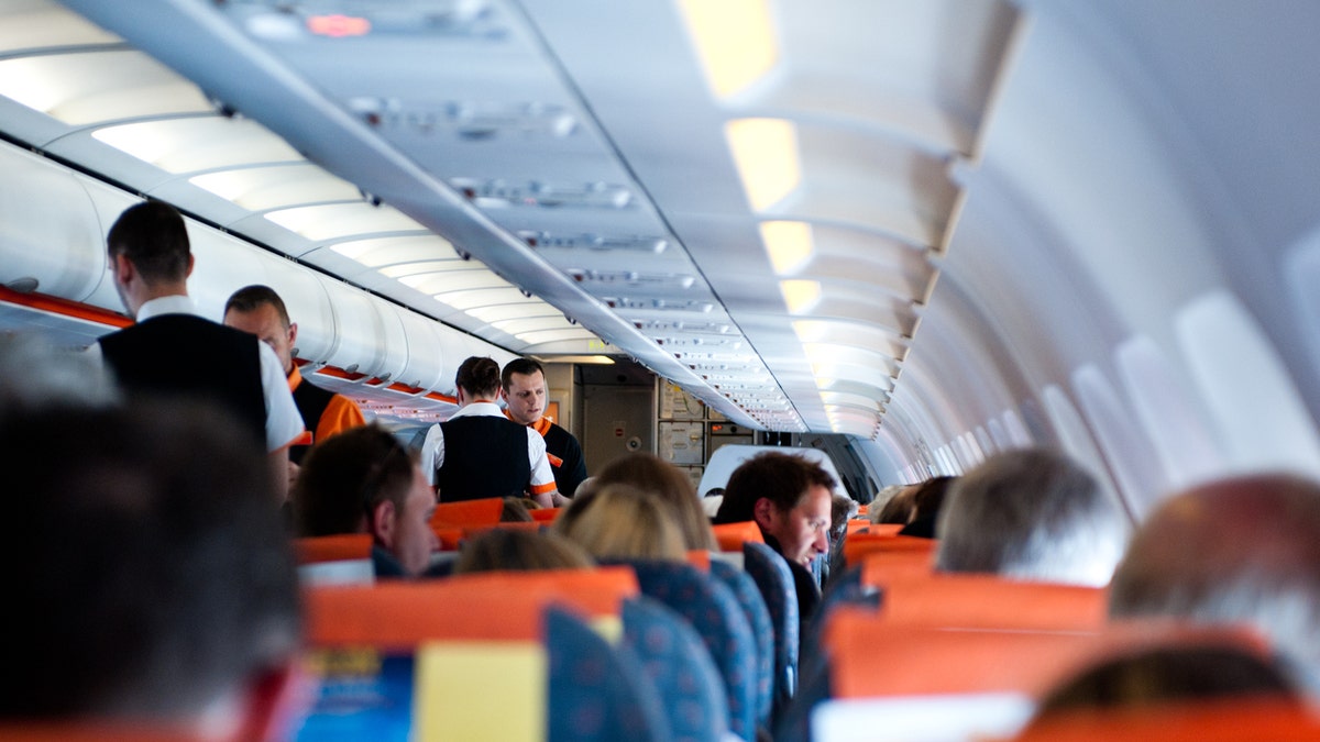 London, UK - May 12, 2013: Flight crew and passengers on board an Easyjet flight from Ajaccio to London. IATA forecast shows that airlines expect to welcome 3.6 billion passengers in 2016.