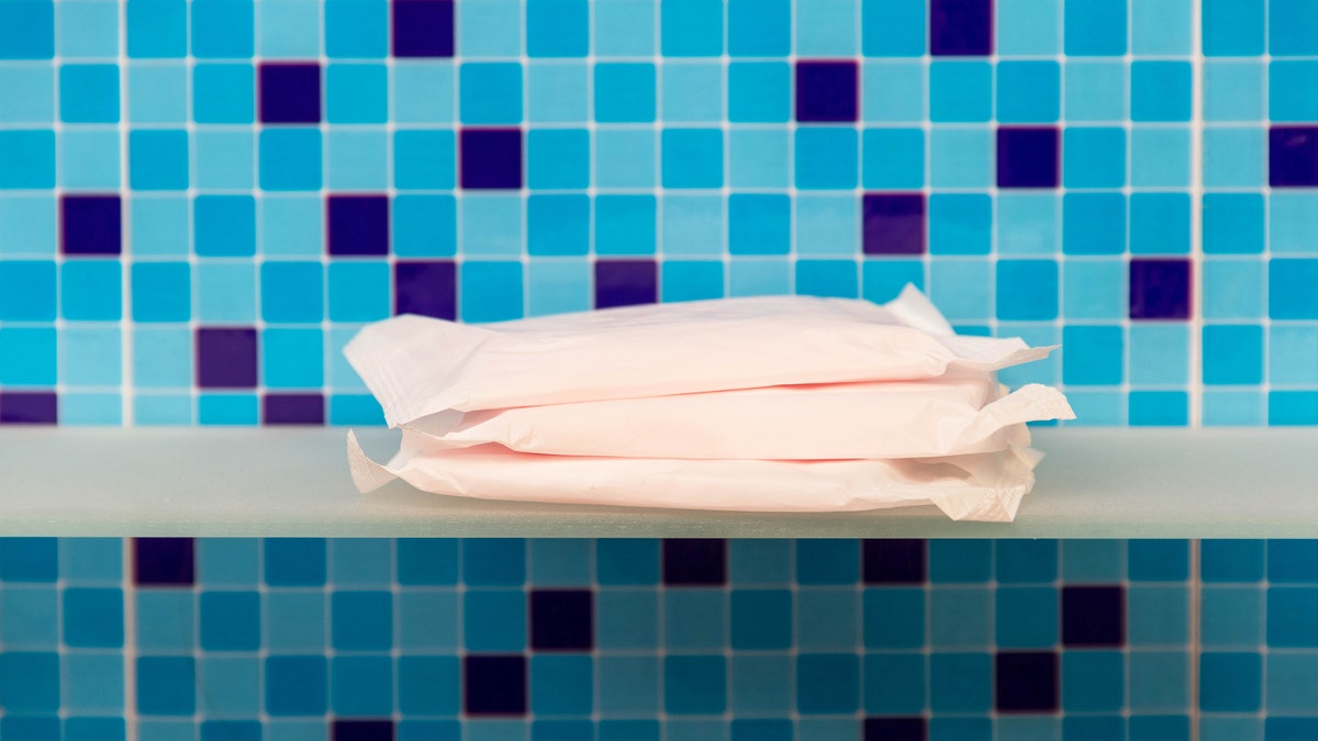 Sanitary towels on shelf and blue background - beauty treatment