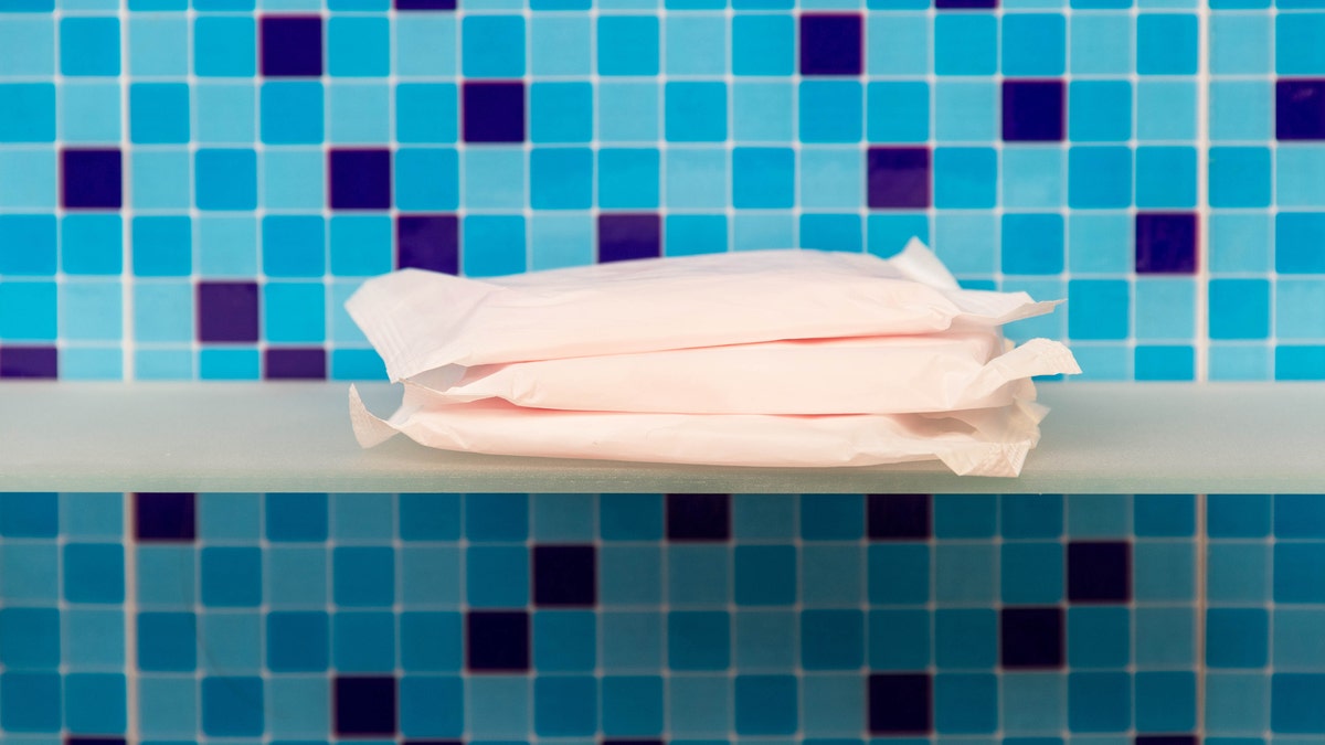 Sanitary towels on shelf and blue background - beauty treatment