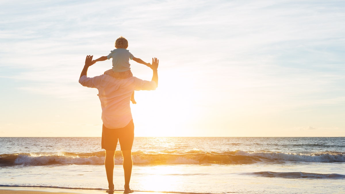 Happy Father and Son Having Fun Playing on the Beach at Sunset. Fatherhood Family Concept