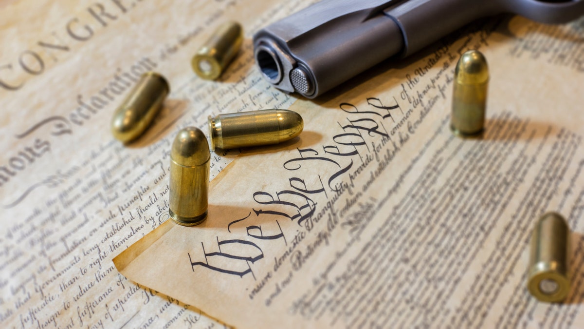 The US Constitution and a gun with bullets
