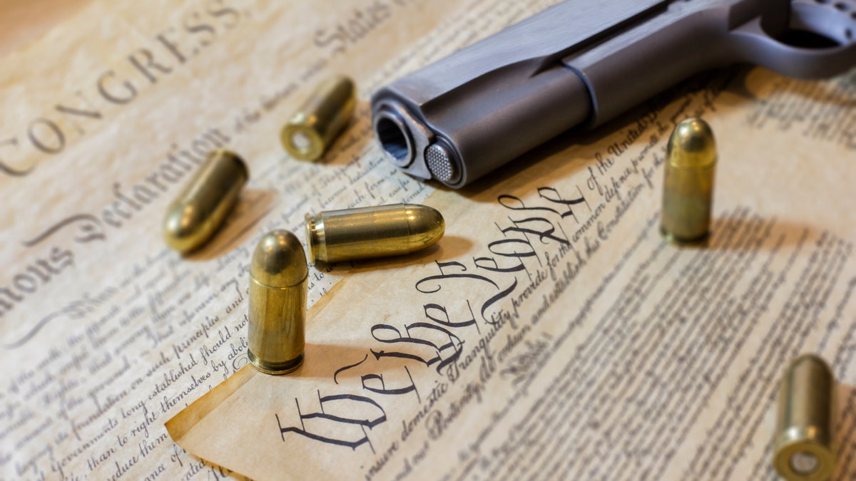 The US Constitution and a gun with bullets