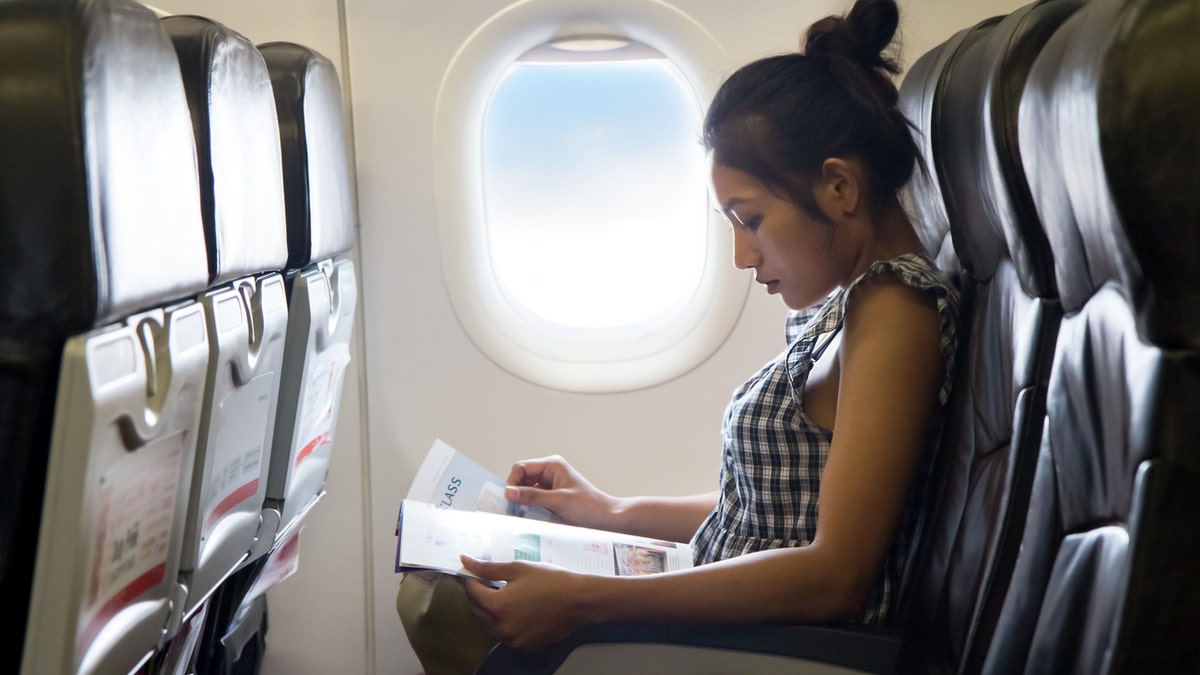 Young woman sits in a chair of the airplane