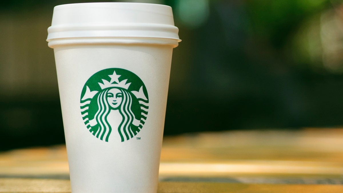 Tall Starbucks to go cup on wooden table