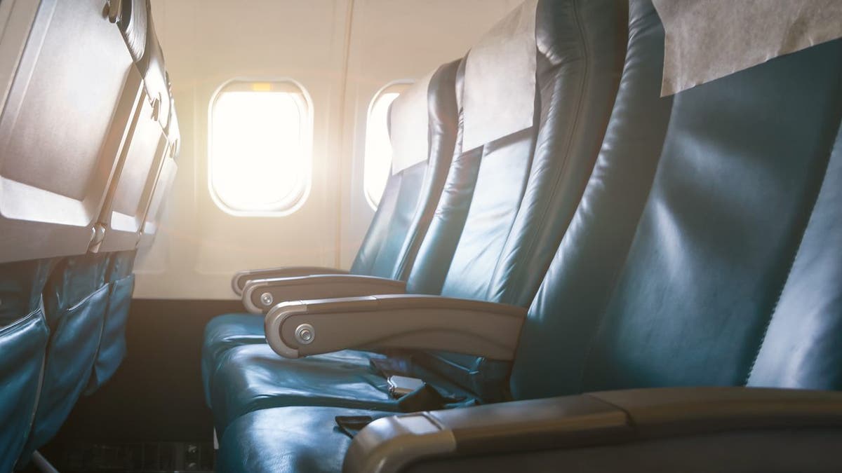 Interior of airplane with empty seats and sunlight at the window. Travel concept.