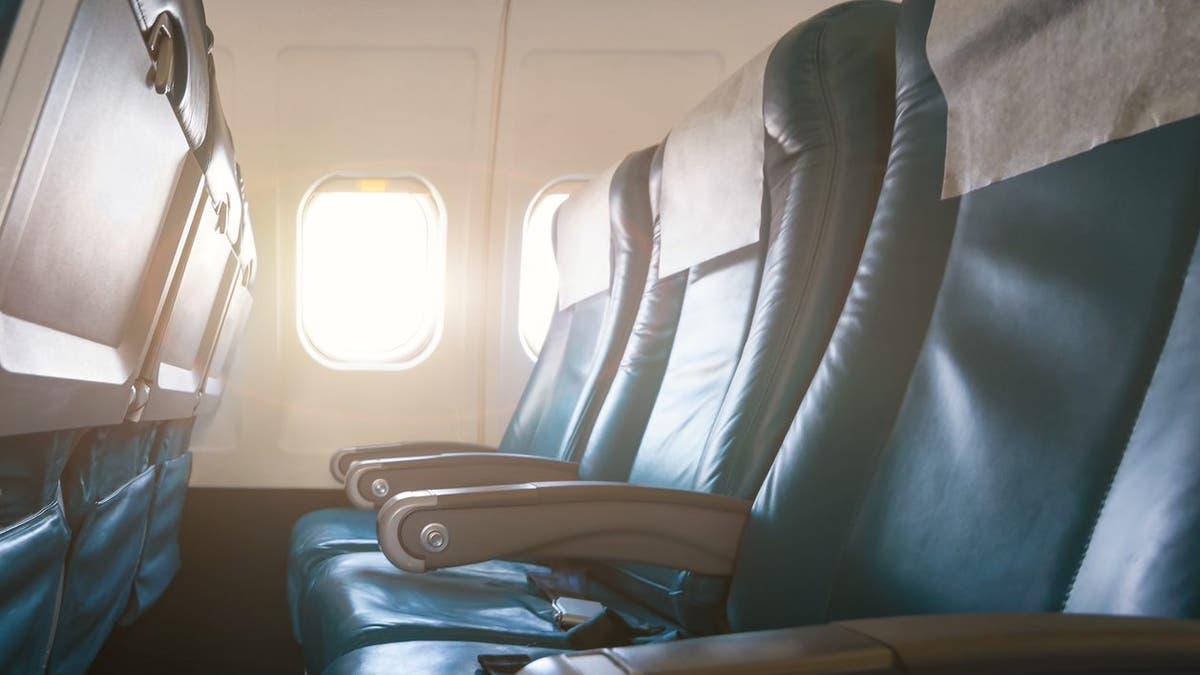 Interior of airplane with empty seats and sunlight at the window. Travel concept.