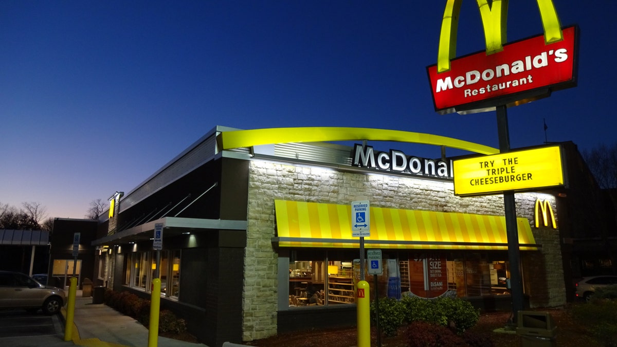 Washington DC, USA-January 19, 2015: This McDonald's fast food restaurant was spotted in Northwest Washington DC on Wisconsin Avenue at dusk. The neon sign is advertising the new triple cheeseburger sandwich. This is a budget priced burger for $2.19 in Washington DC though prices vary depending upon location. 