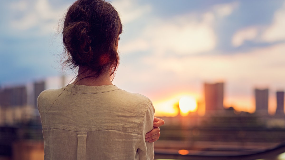 Young girl is watching sunset over Tokyo in Odaiba.