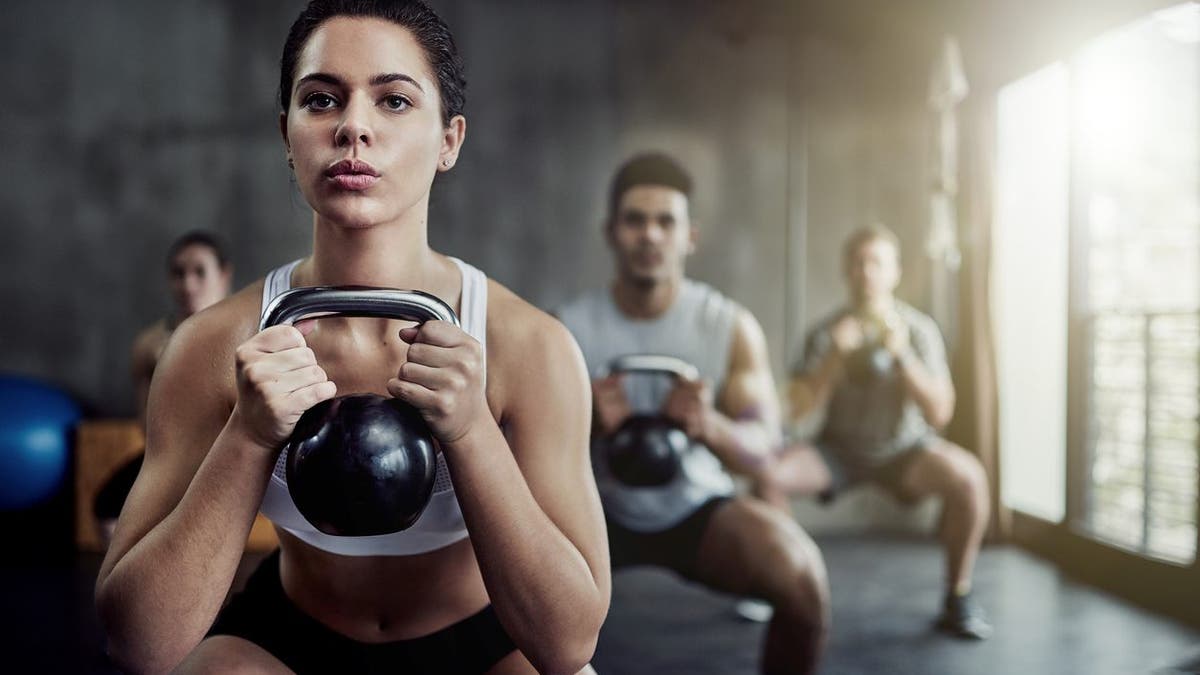 Shot of a fit young woman working out with a kettle bell at the gym