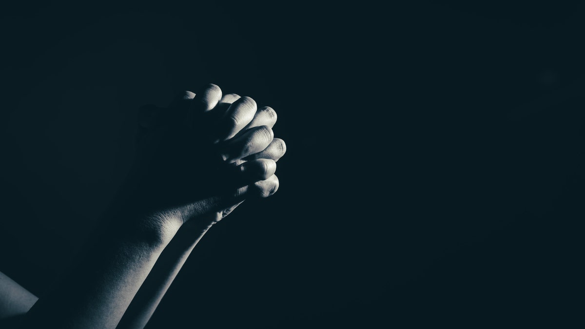 praying woman hand in the dark ( praying in secret room concept )in white tone